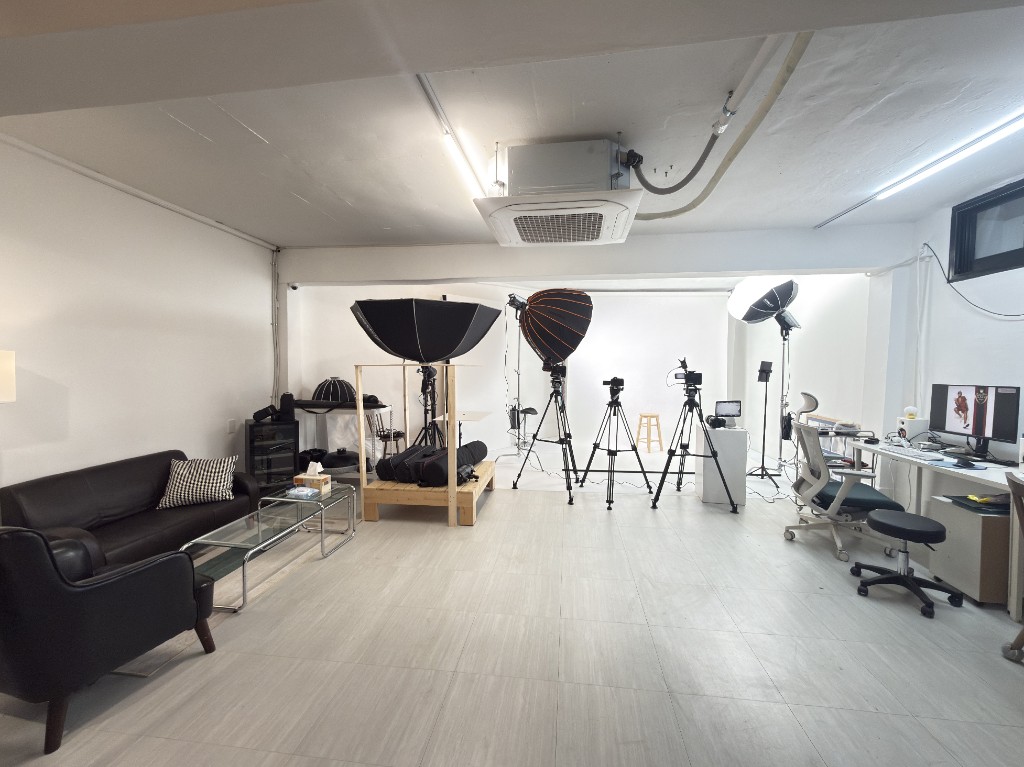 Wide view of TEAM CHAELOG in-house studio with white cyclorama and lighting rigs